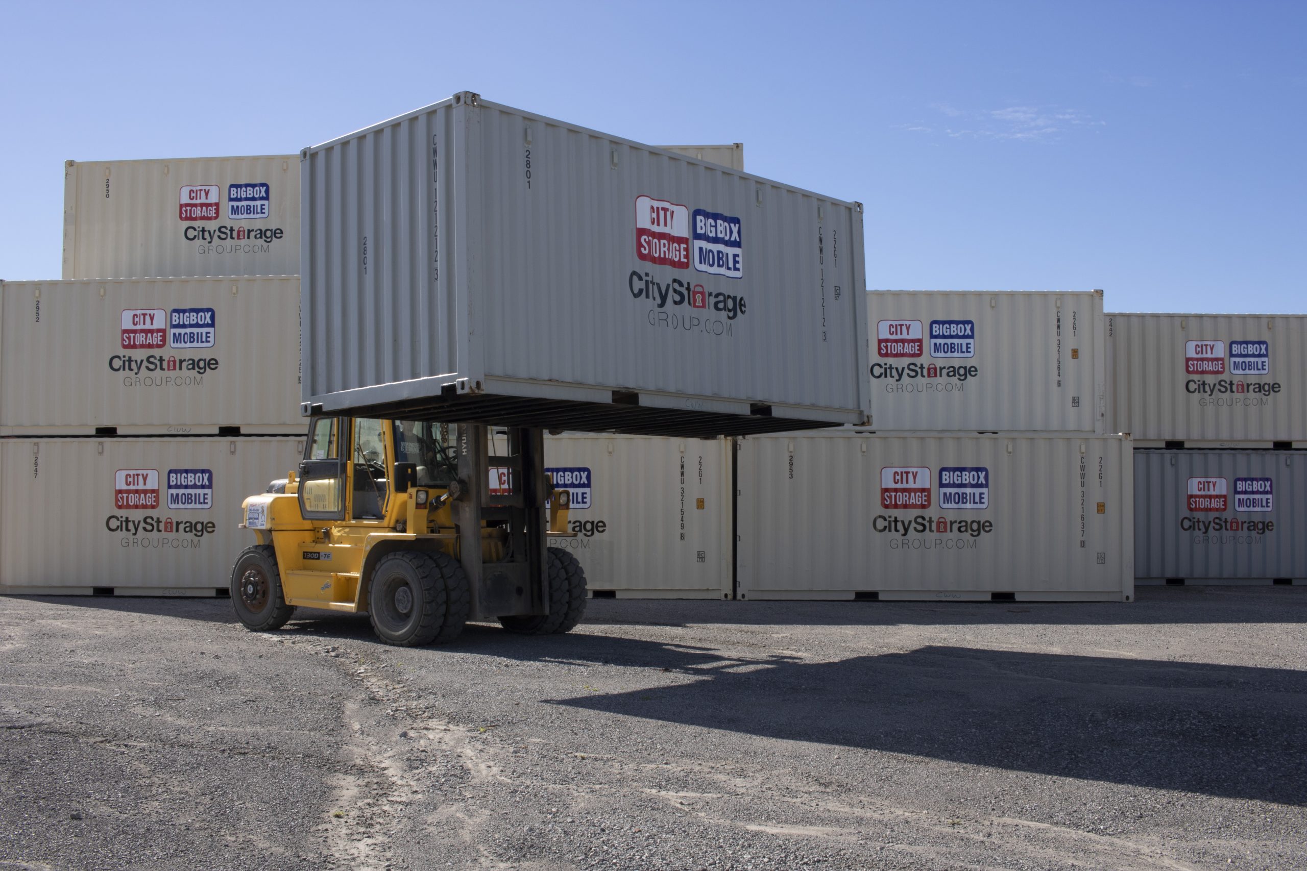 shipping containers used for storage at Big Box Mobile lot in London, Ontario - one lifted up with forklift